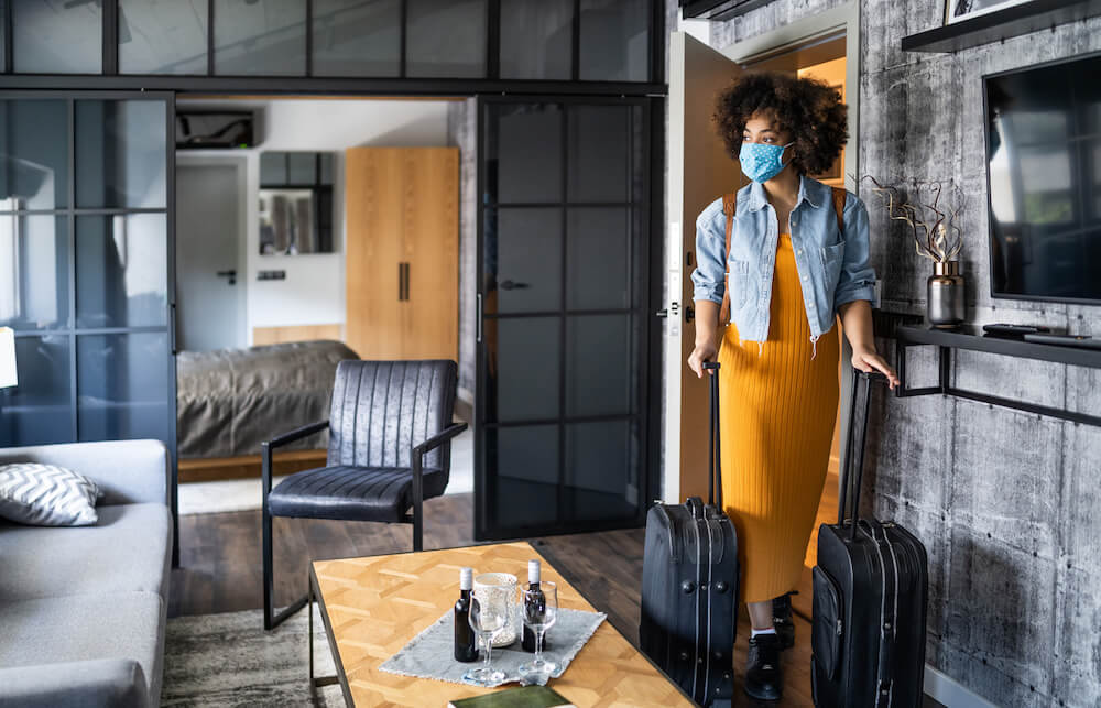 Guest in hotel room wearing a mask